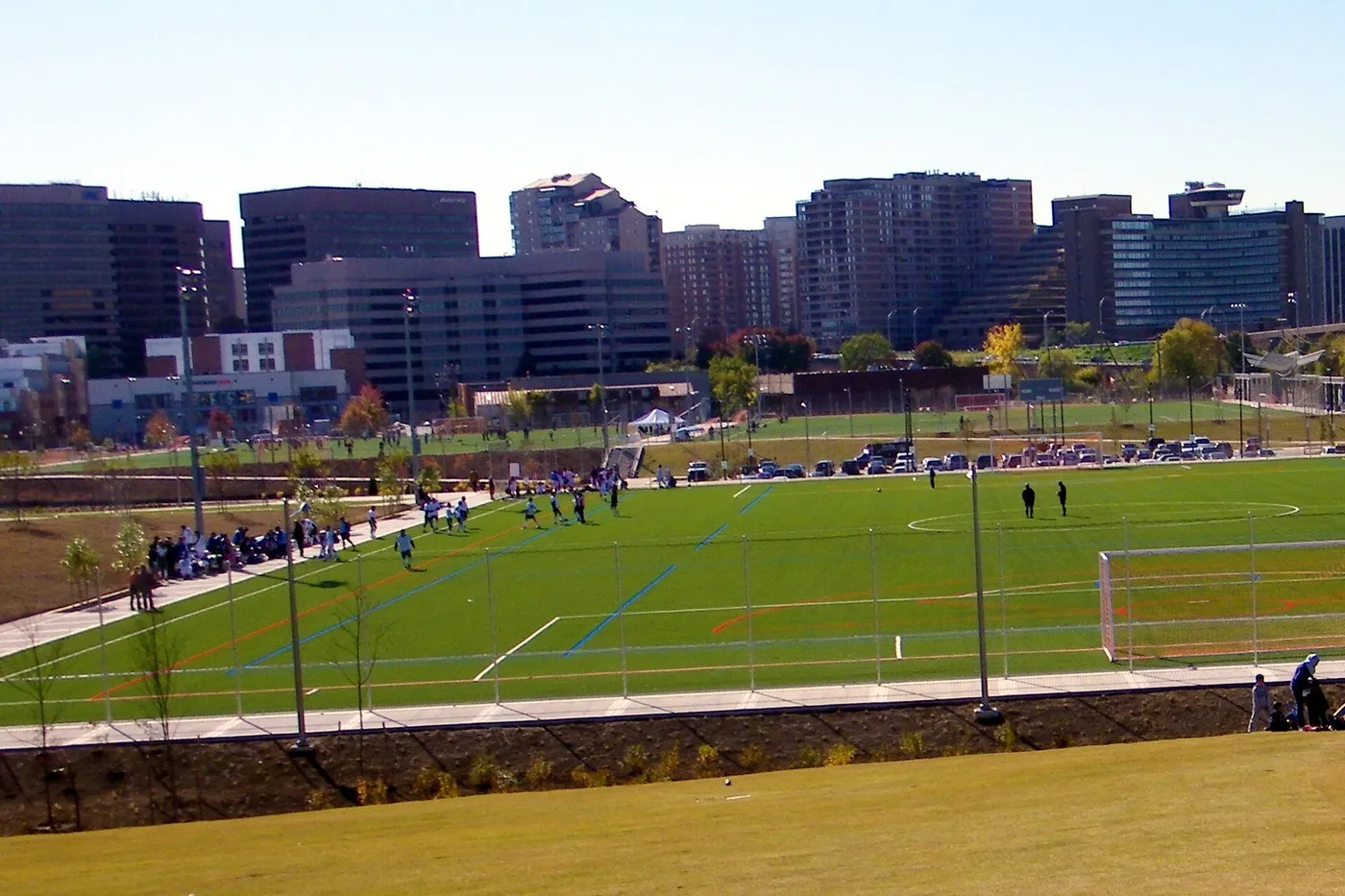Playing fields at Long Bridge Park, with the National Landing towers behind